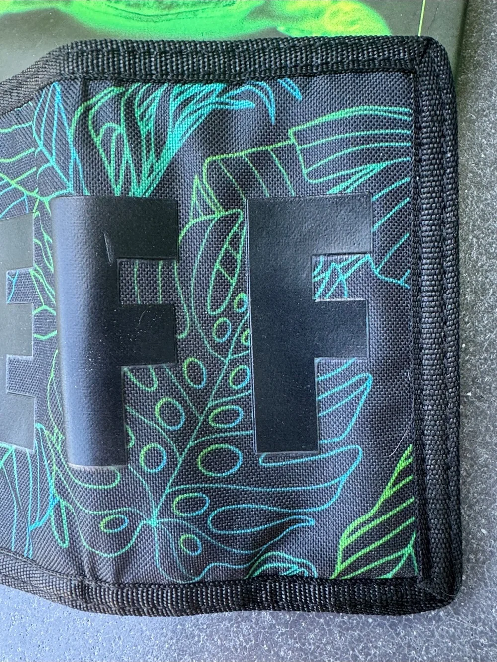 NWOT NEFF black background with tropical theme trifold wallet. Zipper pocket.